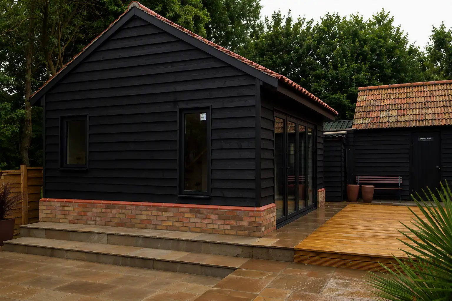 Black clad garden room with a clay tiled roof
